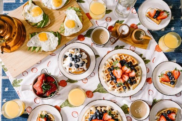 Family breakfast table with waffles, eggs, juice and coffee